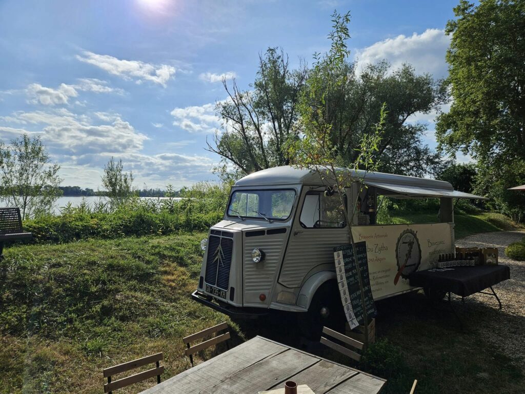 Camion de la brasserie avec banderole et paysage 