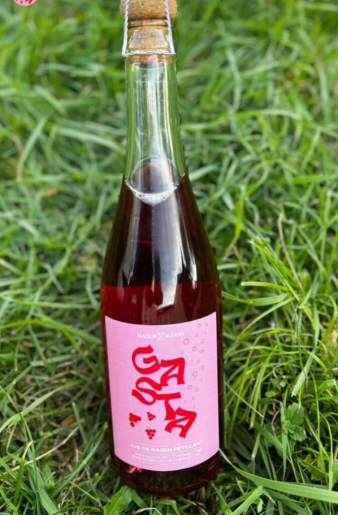 Bouteille de jus de raisin pétillant  prise dans l'herbe