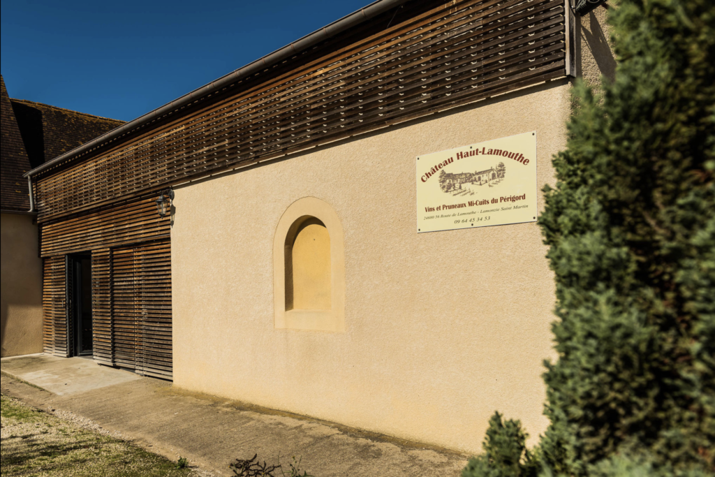 chais du château avec panneau avec le nom du domaine.